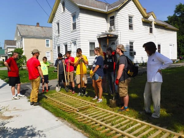 A team of young Northwest Rutland neighborhood volunteers installing a fence in Rutland, Vermont